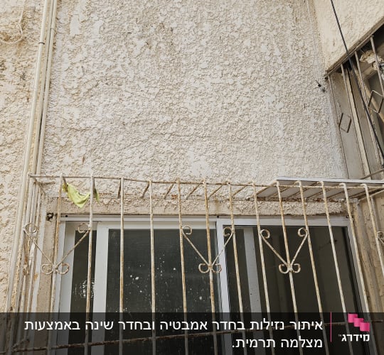 קיר חיצוני עם חלון וסורגים חלודים